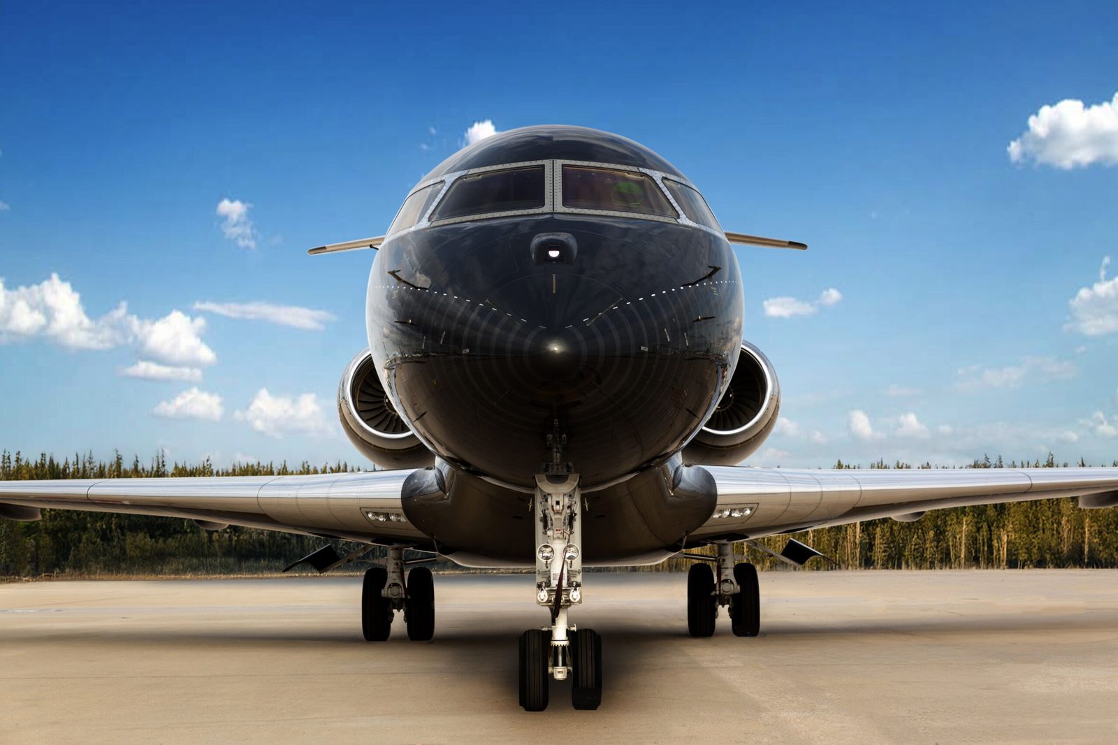 Business jet seen head on, parked on the apron